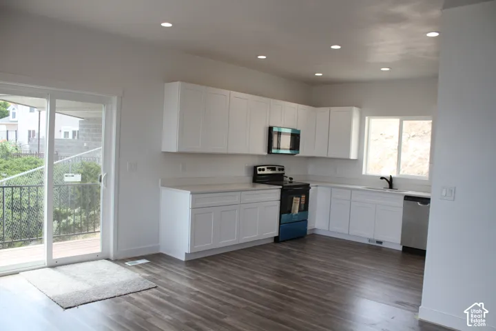Contemporary kitchen featuring white shaker cabinetry and light-toned countertops