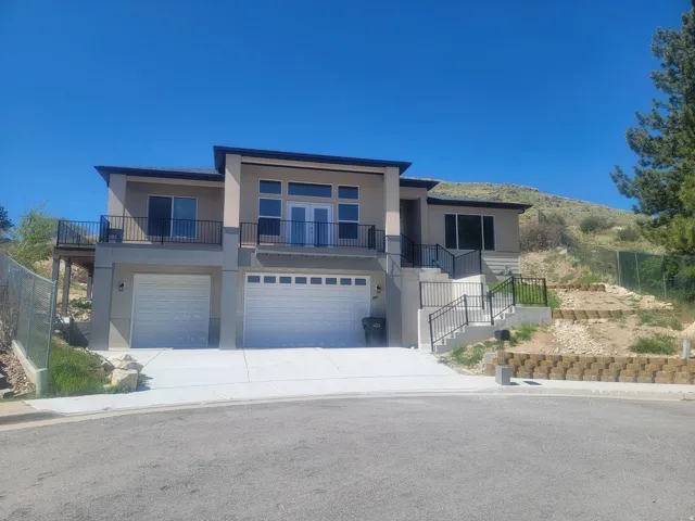 Contemporary multi-level residence featuring a stucco exterior and a combination of fixed and sliding glass doors