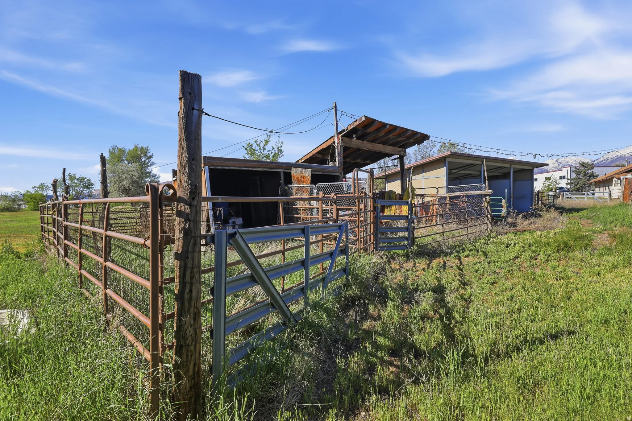 Metal fencing enclosing an outdoor area with a covered structure