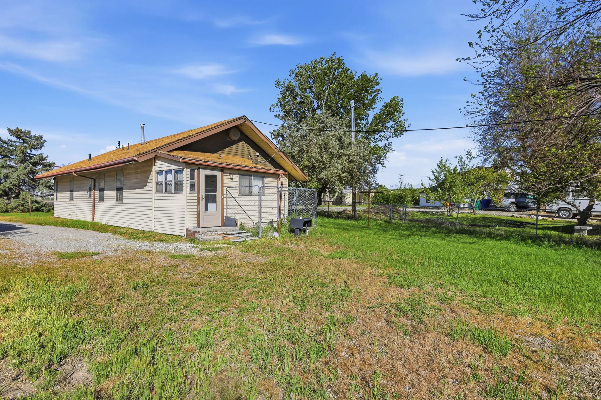 Single-story residence featuring light-colored siding and a brown roofline
