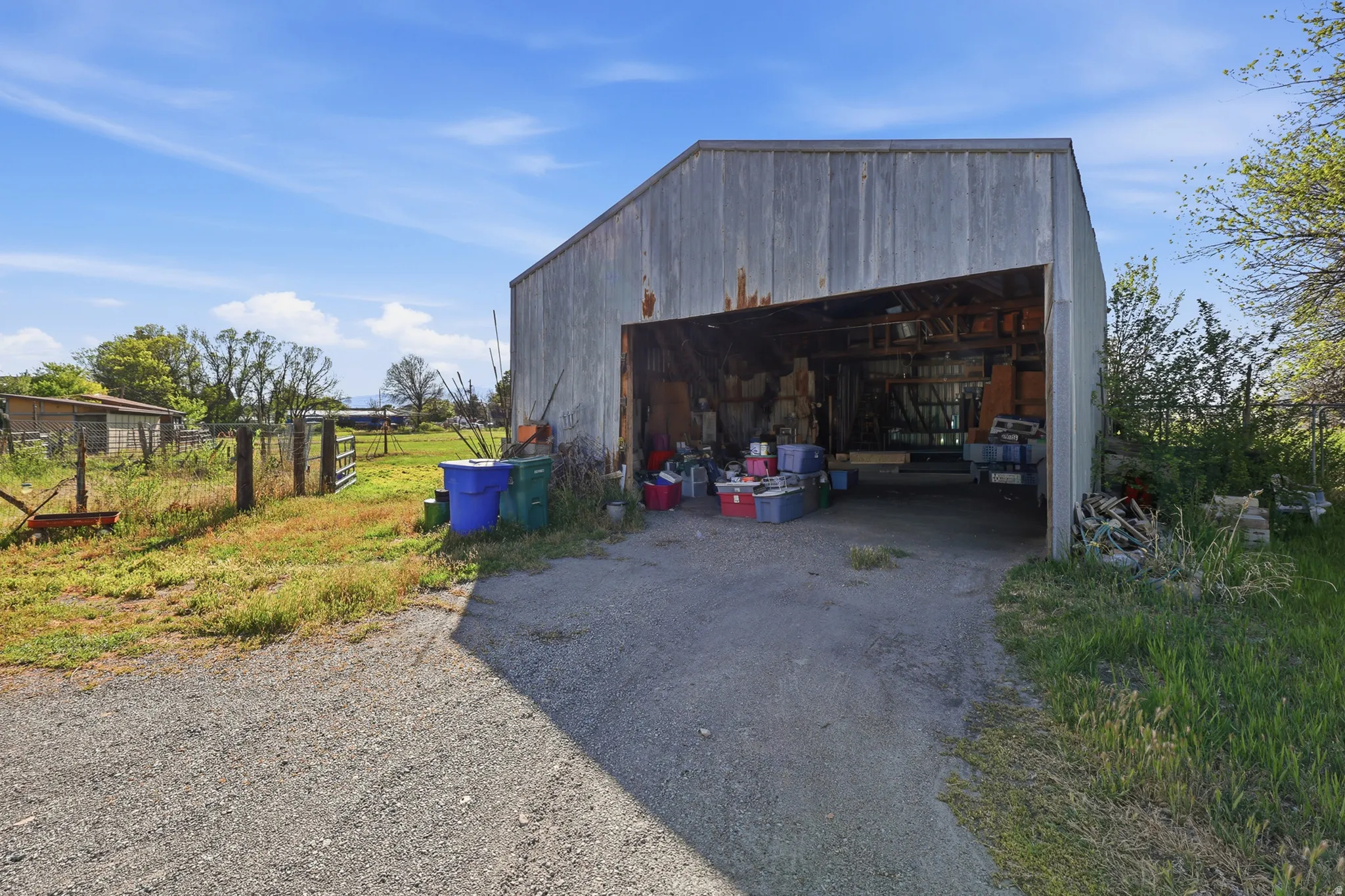 Metal-sided barn structure with a wide, open bay for vehicle or equipment storage