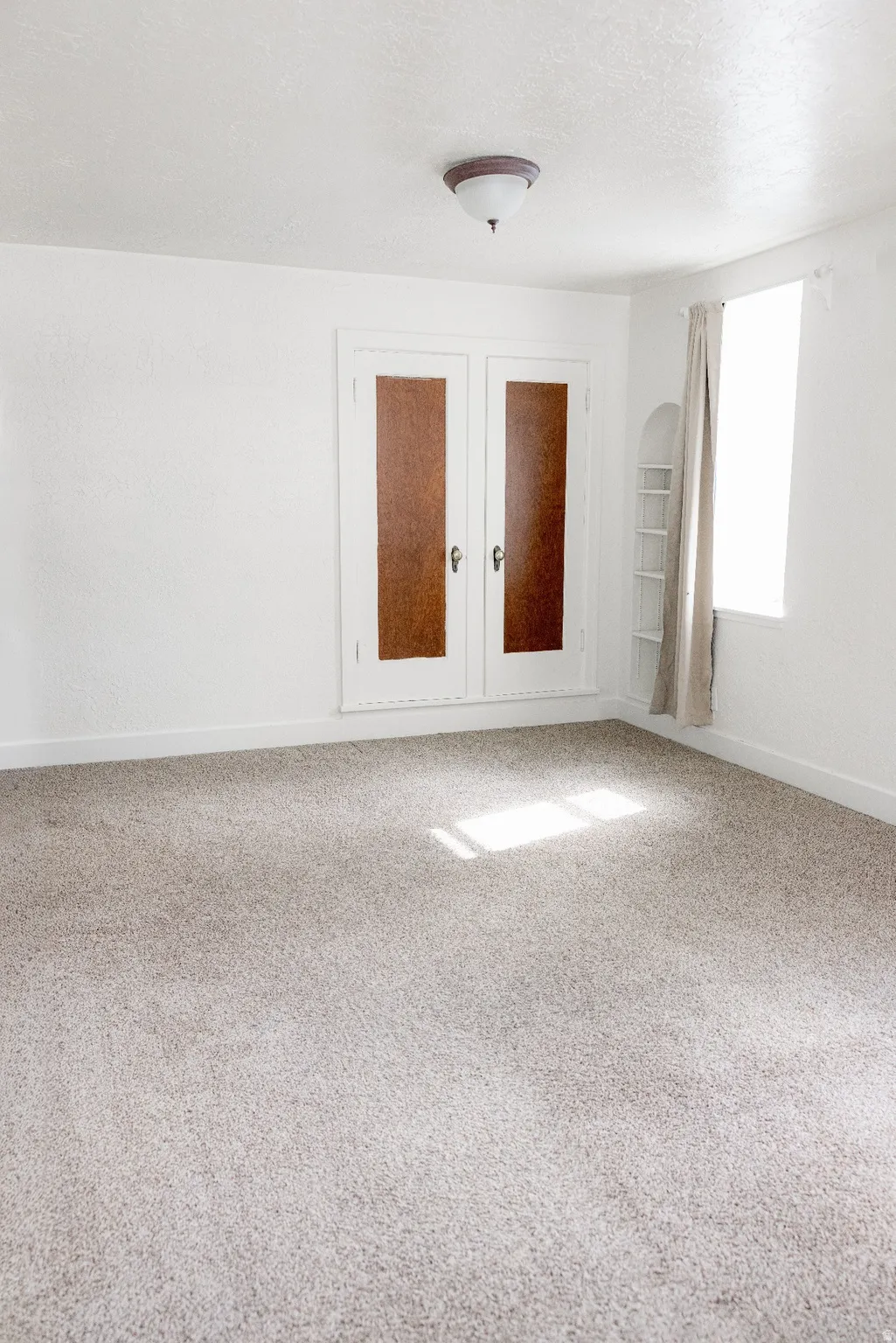 Bright interior space featuring light-toned carpeting and white painted walls