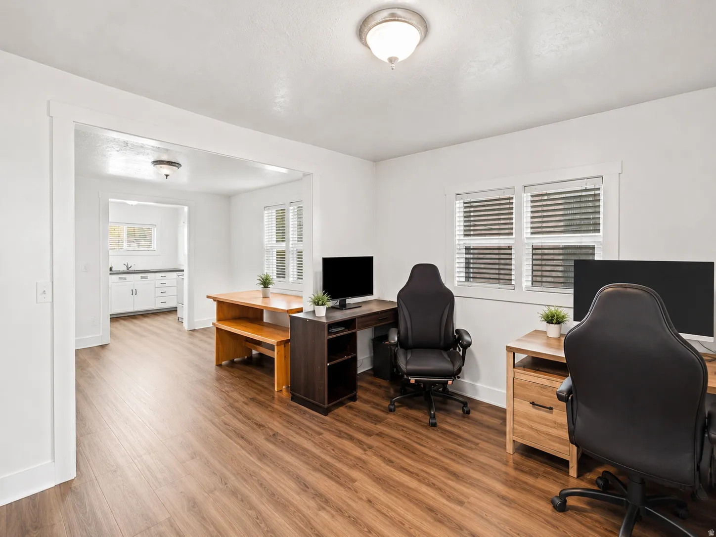 Spacious room featuring wood-finish flooring and white walls