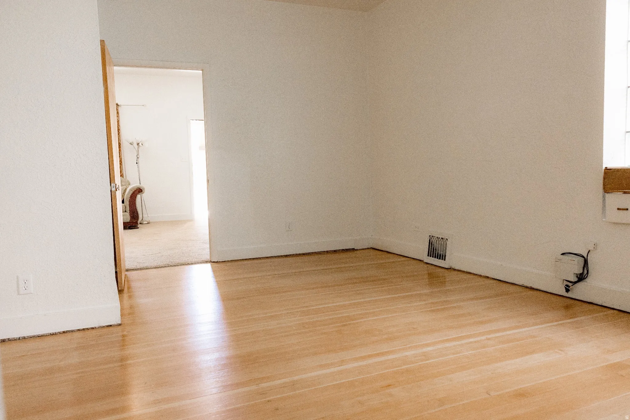 Light wood-finish flooring with white baseboards and neutral wall tones
