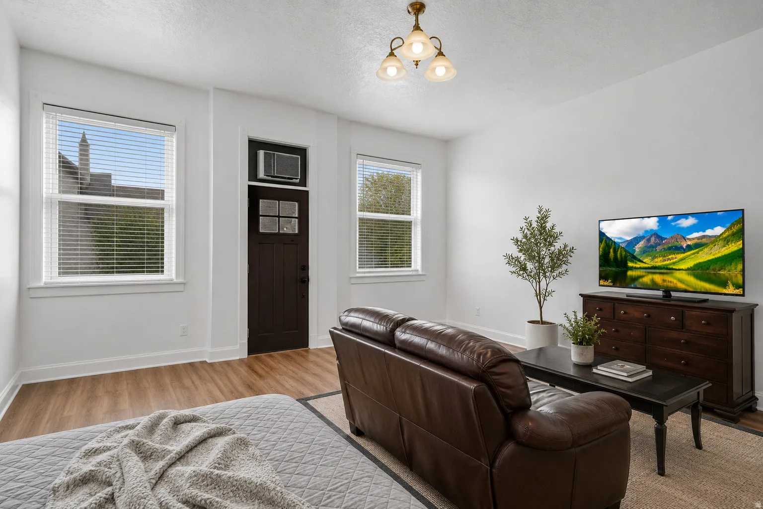 Bright living area featuring wood-finish flooring, white trim, and light-colored walls