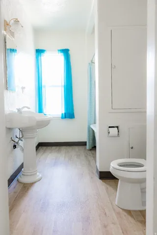 Bathroom featuring wood-finish flooring and a pedestal sink