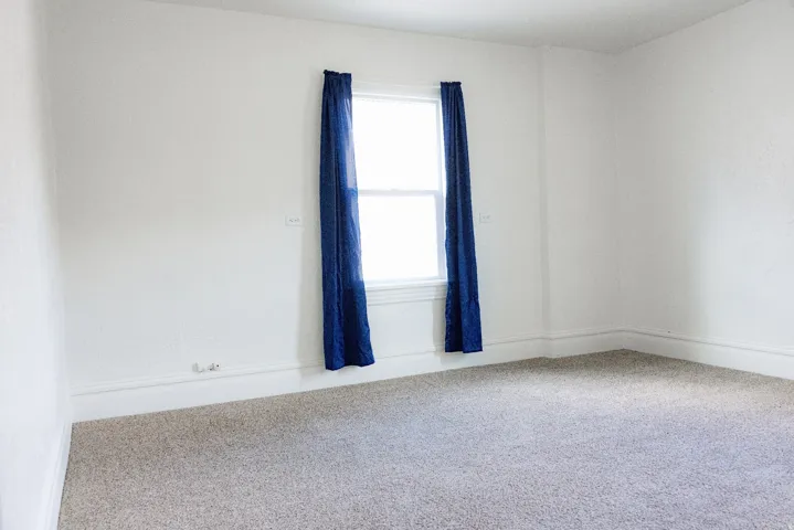 Neutral wall paint with carpeted flooring and white trim