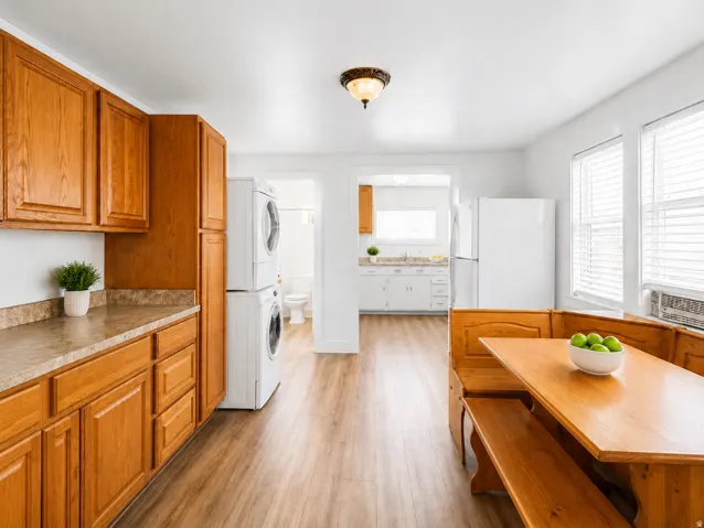 Kitchen area featuring wood-finish flooring, light wood cabinetry, and a patterned laminate countertop