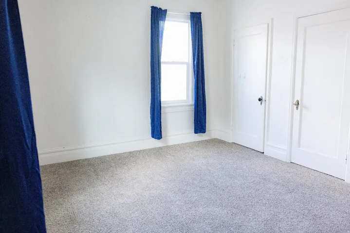 Bright interior room featuring light-colored carpeting and white walls