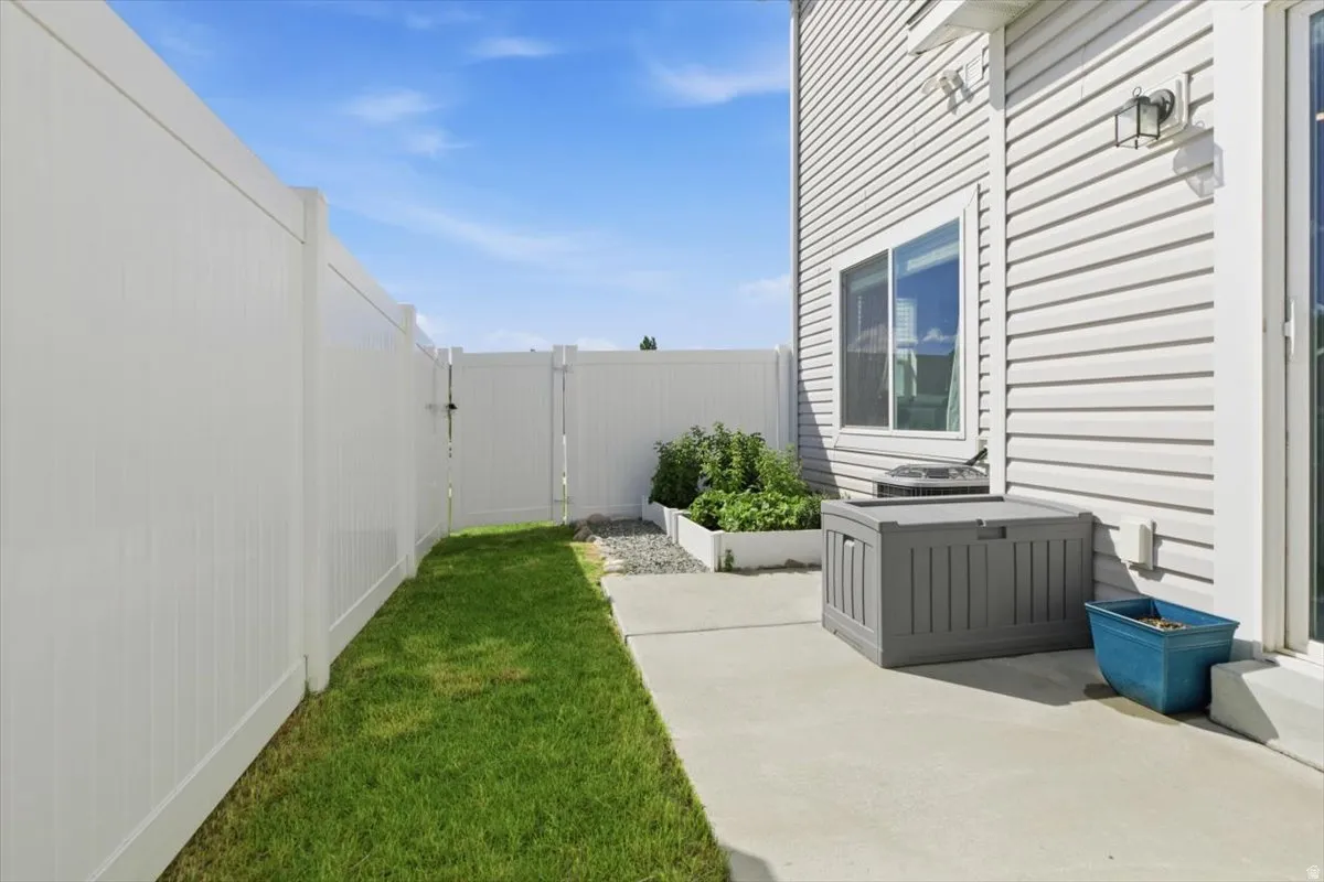 Private outdoor space featuring a white privacy fence and a dedicated gate