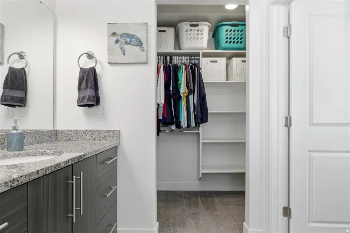 Bathroom vanity with a light granite countertop and undermount sink