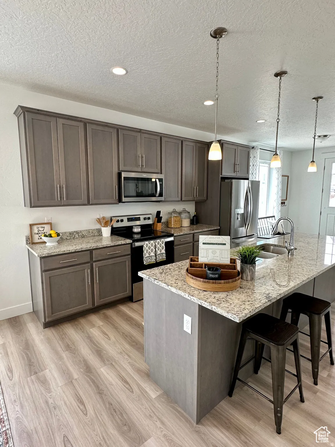 Kitchen featuring wood-finish flooring, recessed ceiling lights, and pendant lighting