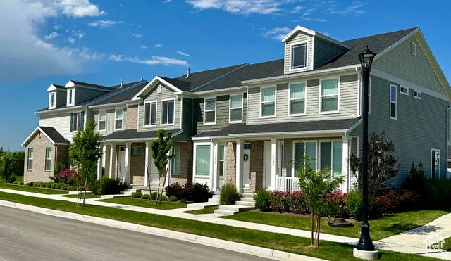 Row of townhomes featuring varied exterior finishes including brick and siding