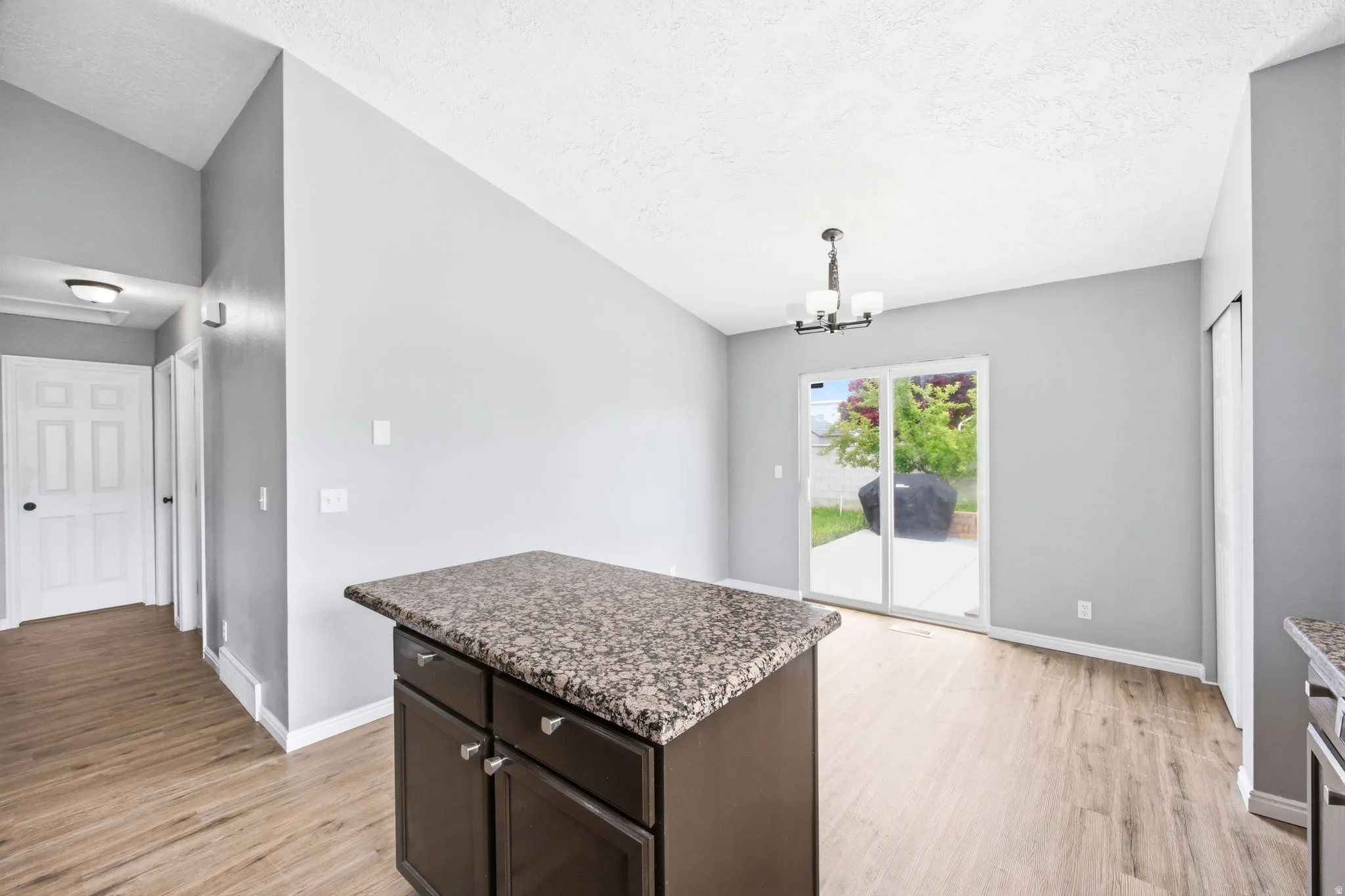 Kitchen island featuring dark wood cabinetry and a speckled countertop