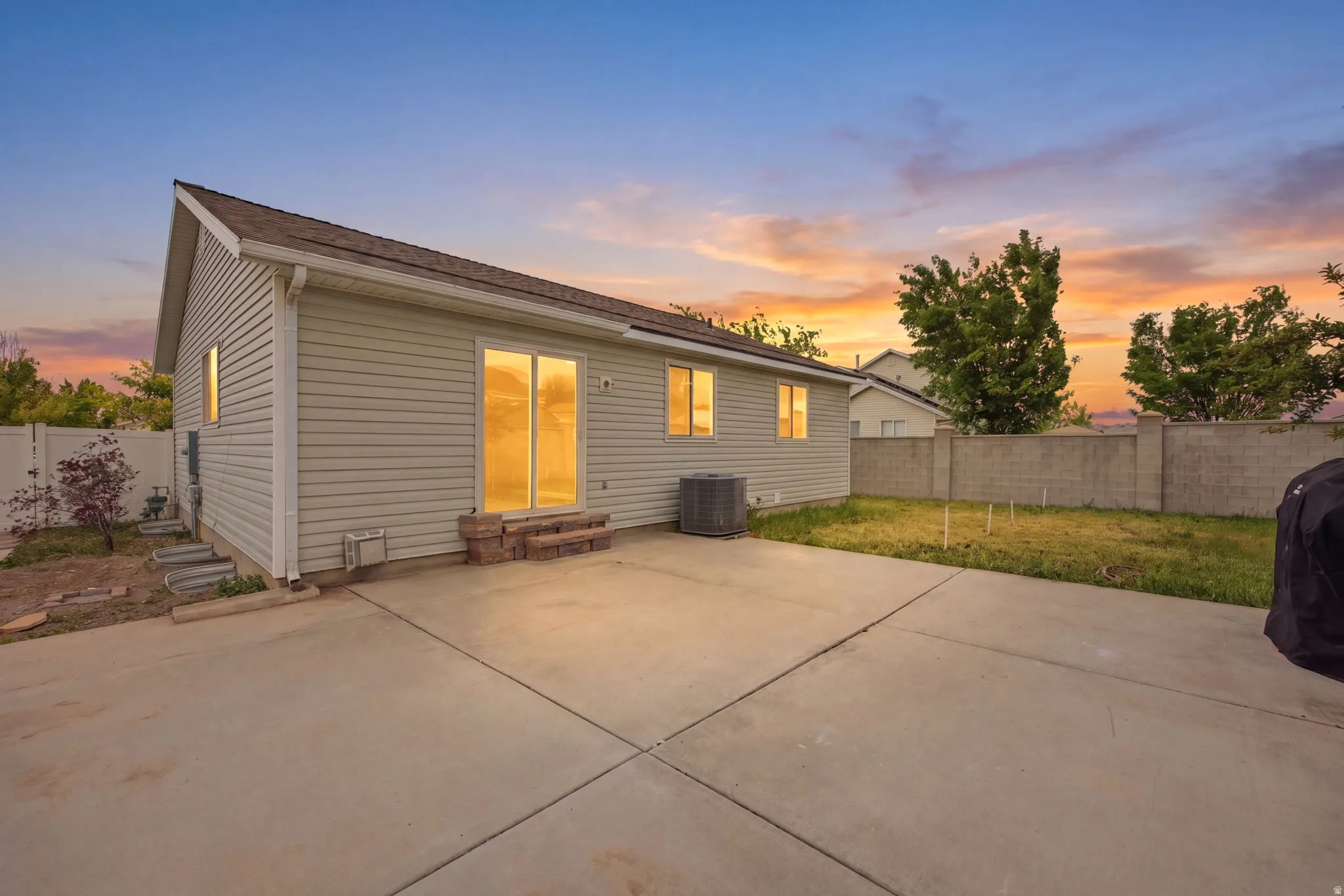 Expansive concrete patio with direct access to the interior via sliding glass doors