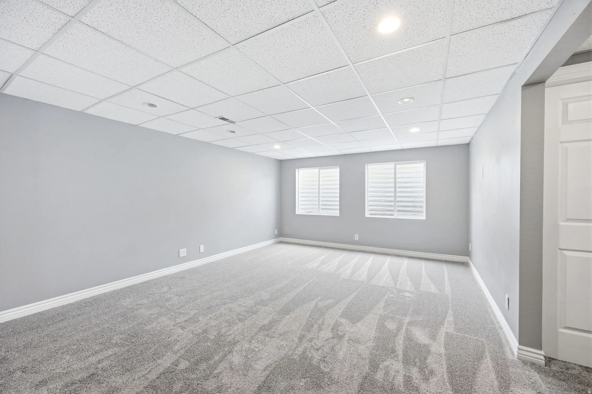 Expansive interior space featuring gray textured carpeting and light gray wall finishes