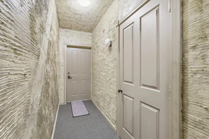 Entryway featuring textured wall finishes and neutral-toned four-panel doors