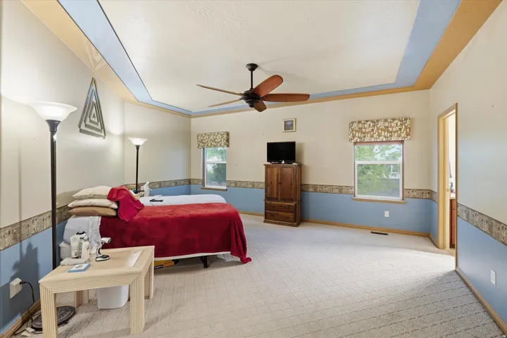 Spacious room featuring a tray ceiling, recessed lighting, and a ceiling fan