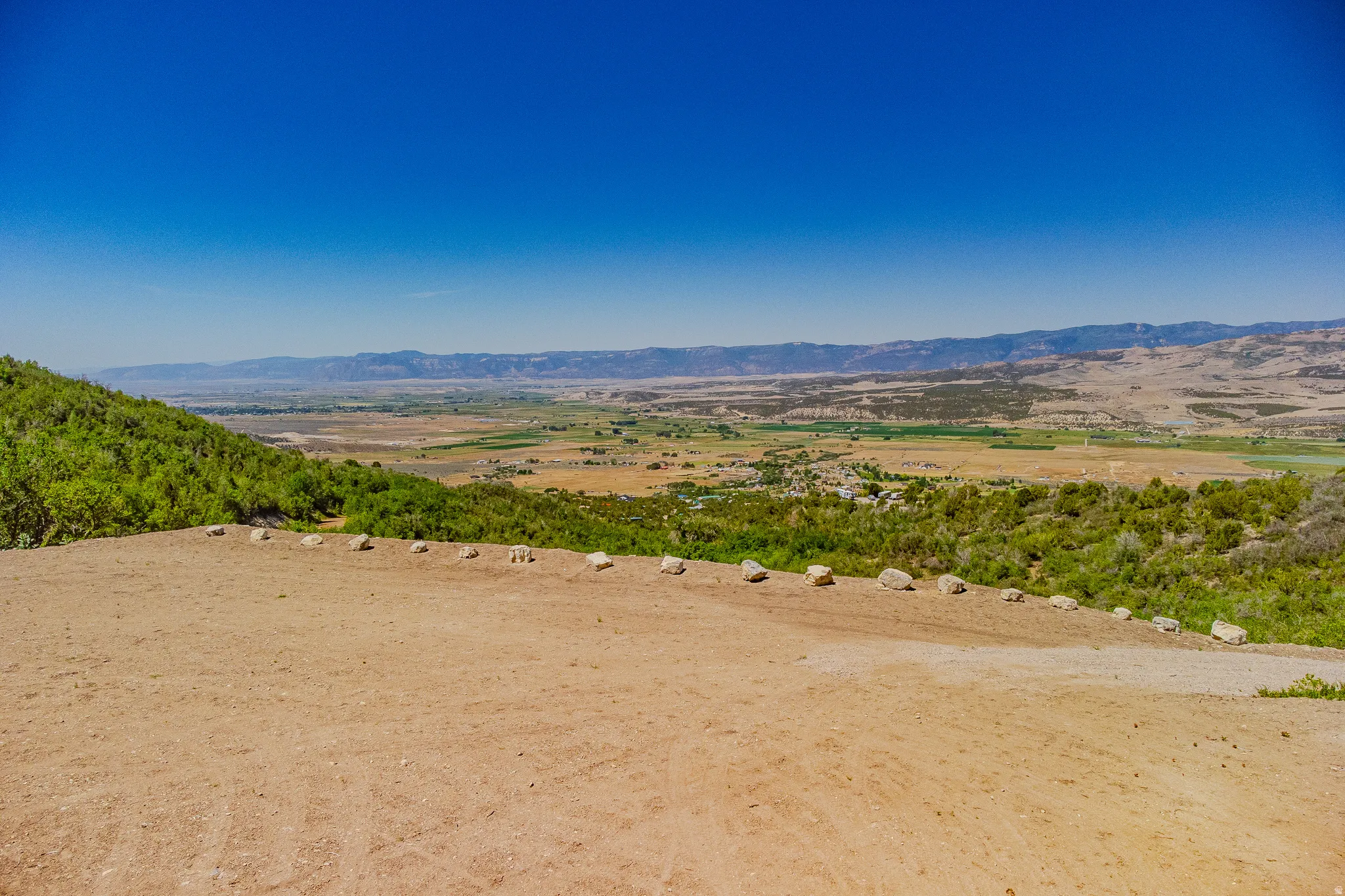 Expansive undeveloped parcel featuring a wide-open terrain, natural rock formations, and distant mountain ranges