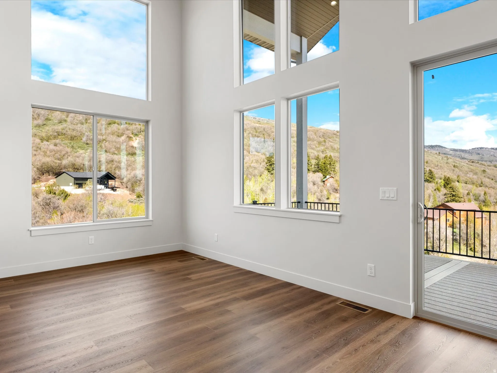 Two-story living space featuring wood-finish flooring