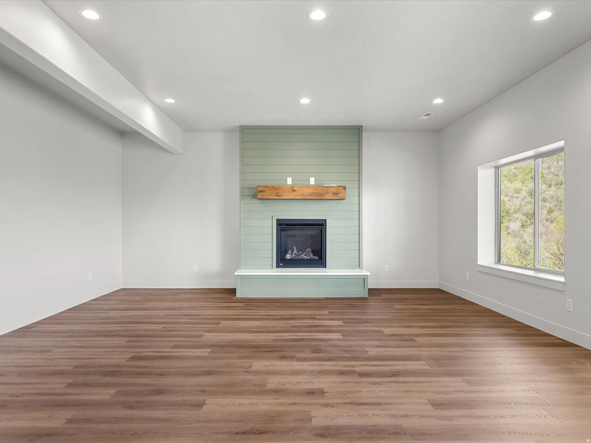 Spacious interior featuring wood-finish flooring and recessed lighting