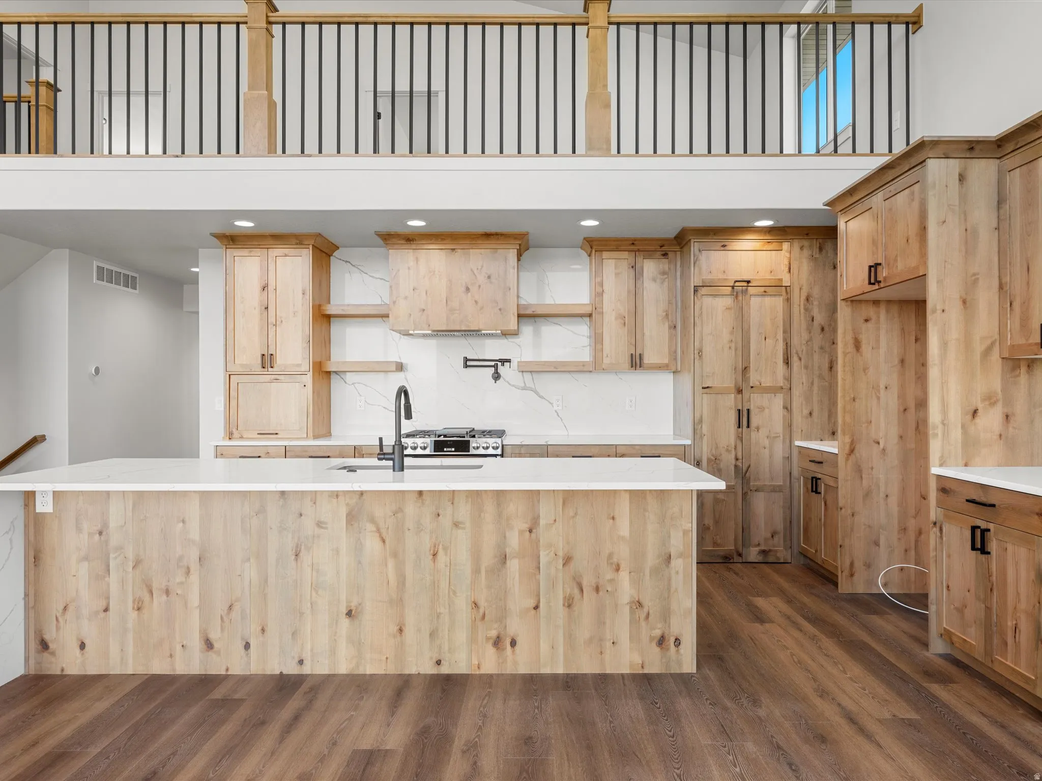 Gourmet kitchen with natural wood cabinetry and a large central island