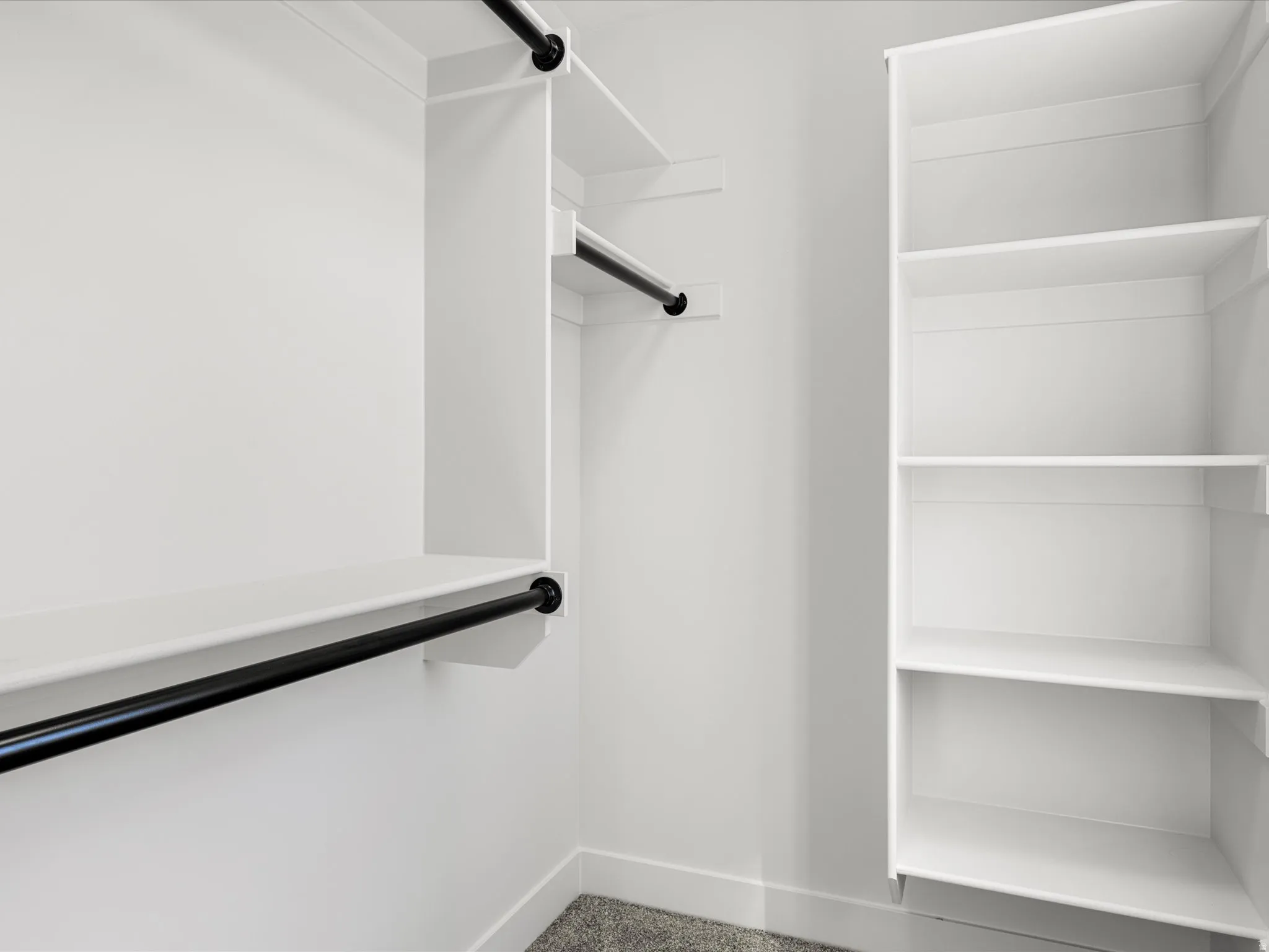 Custom closet system featuring white shelving and black hanging rods