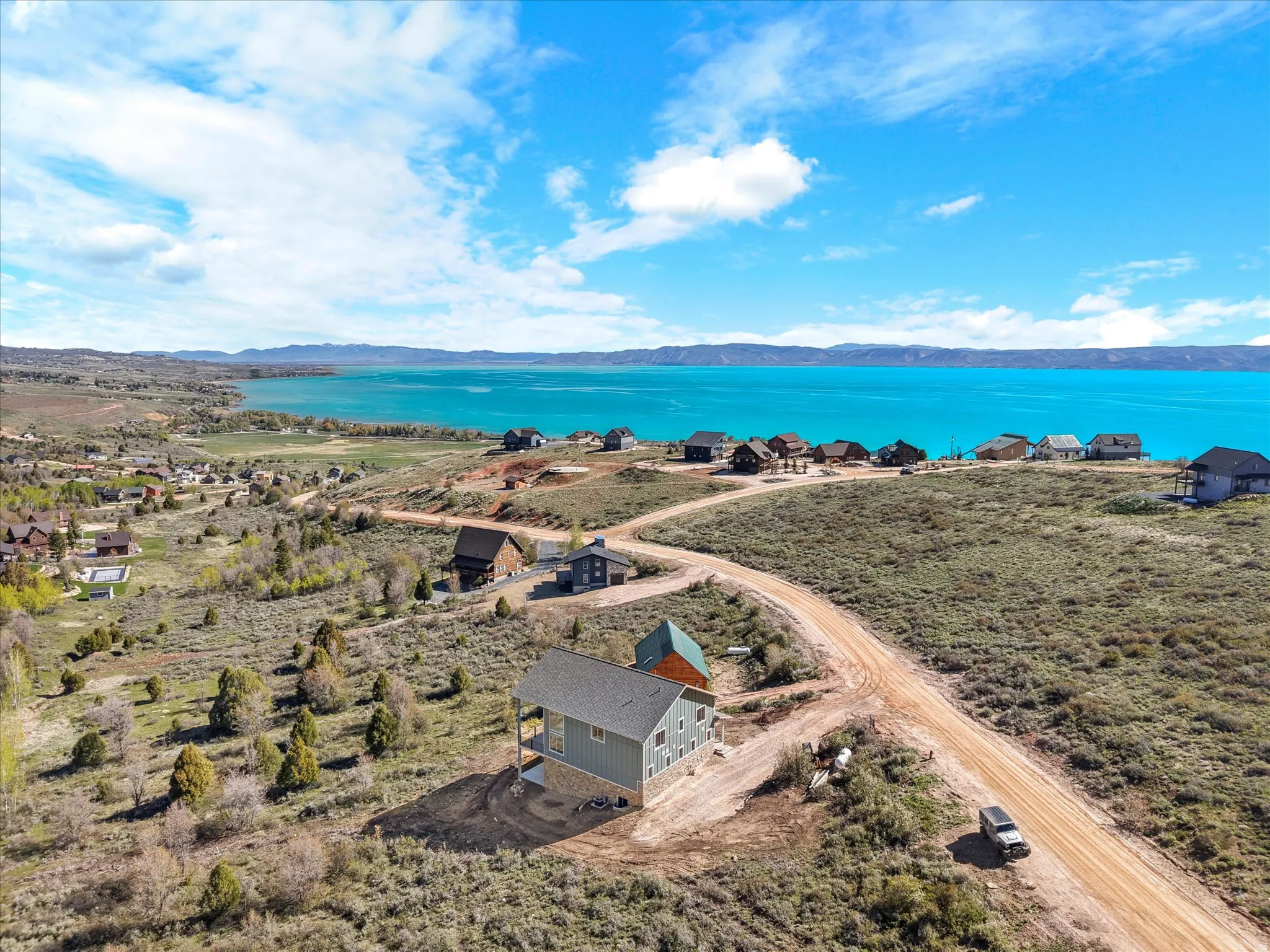 Aerial perspective showcasing a property with a light blue exterior and dark gray roof