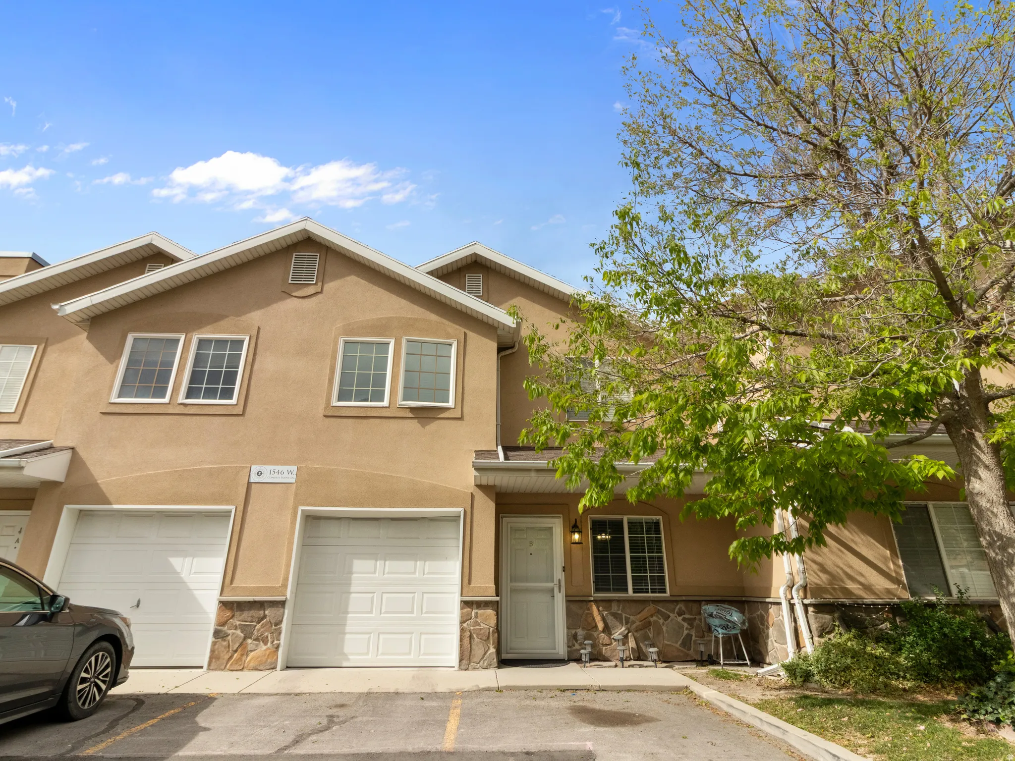 Townhome exterior featuring stucco siding and stone veneer accents