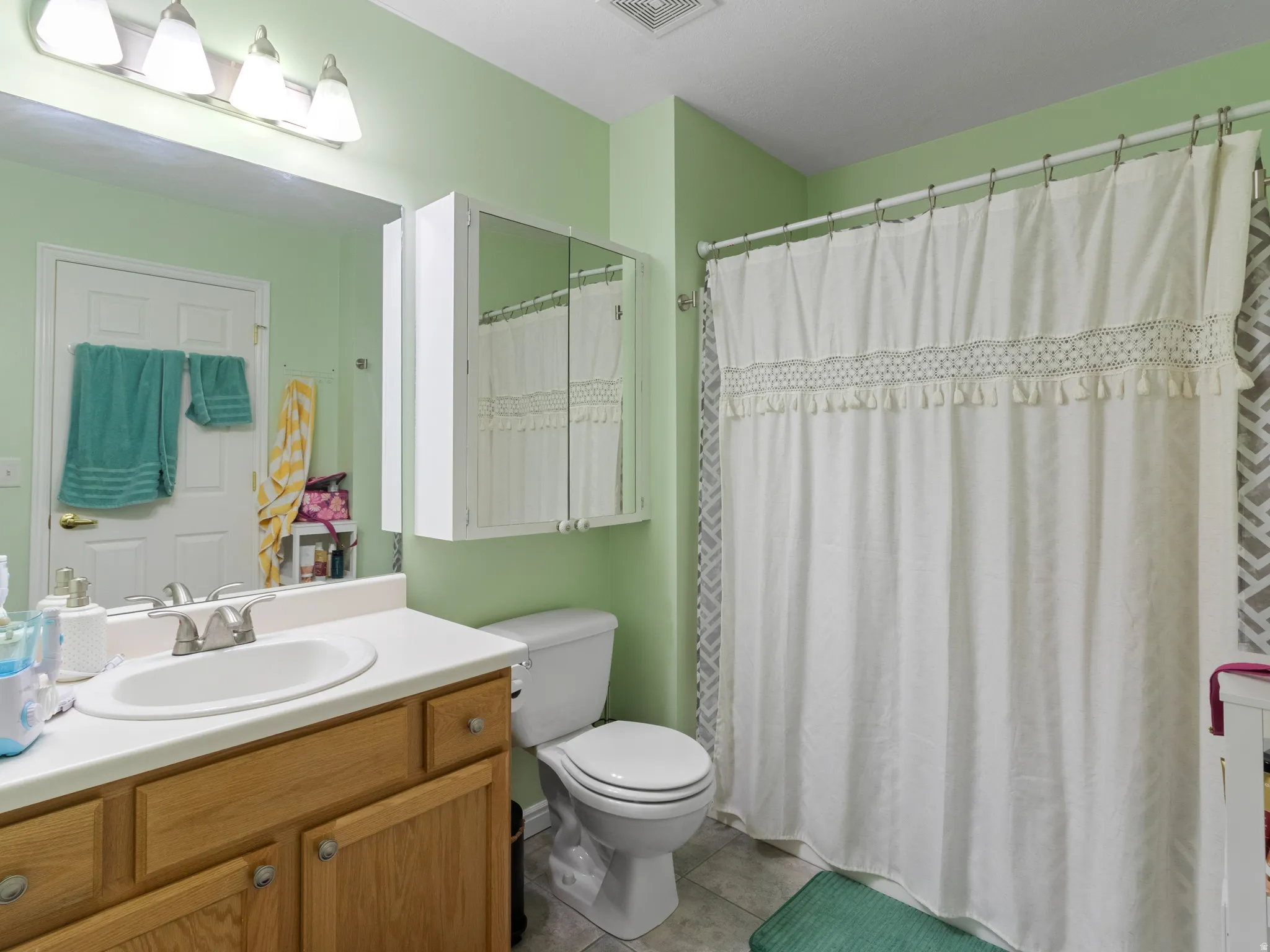 Bathroom featuring a vanity with a white countertop and wood-finish cabinetry