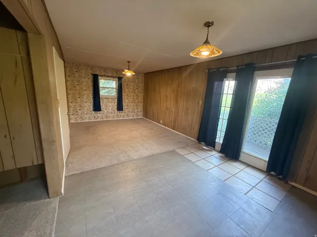 Interior space with mixed flooring, featuring a carpeted area and tiled sections