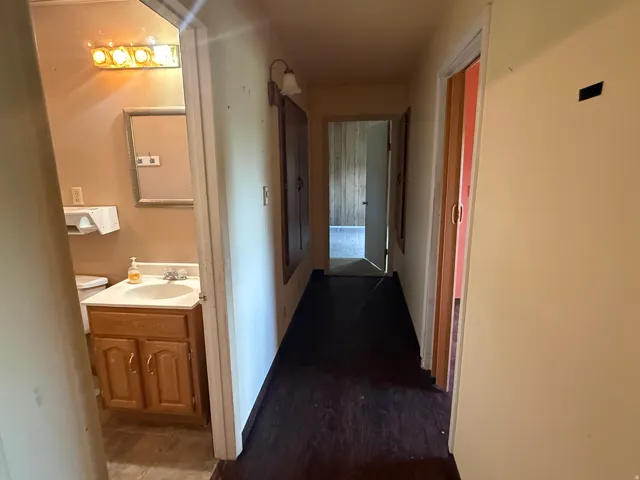 Hallway featuring dark wood-finish flooring