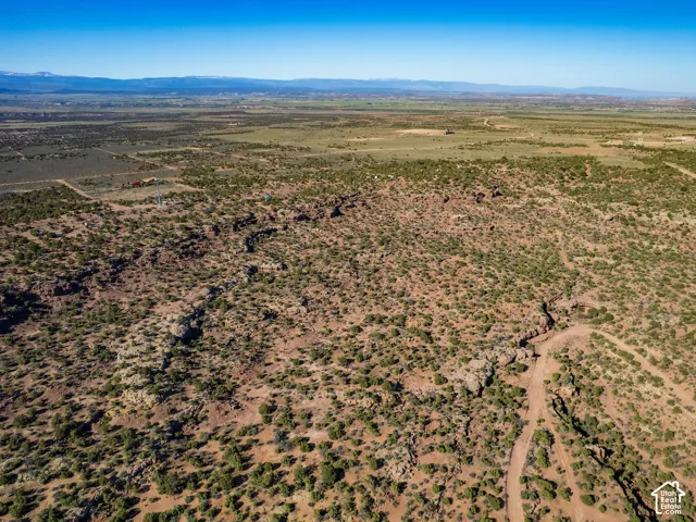 Expansive undeveloped acreage with varied topography, including rock formations and scattered vegetation