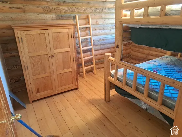 Log-clad walls, natural wood flooring, and a log bunk bed