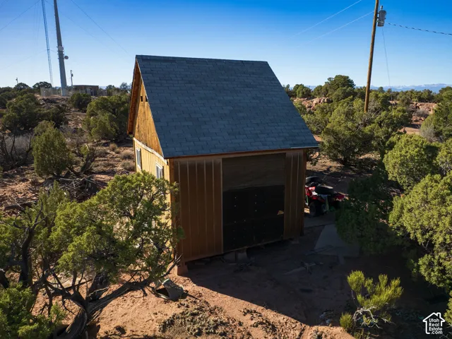 Gable-roofed outbuilding with vertical wood siding and a single window