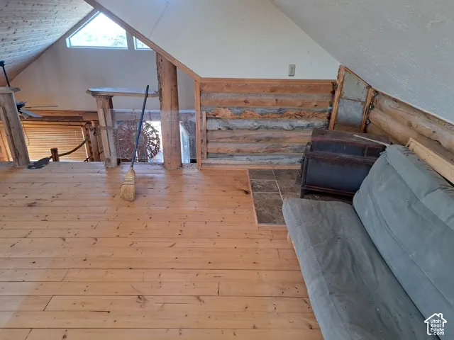 Wood-finish flooring with an angled ceiling and exposed wood beam accents