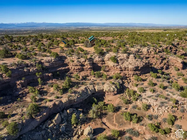 Expansive arid landscape featuring rock formations and sparse green foliage