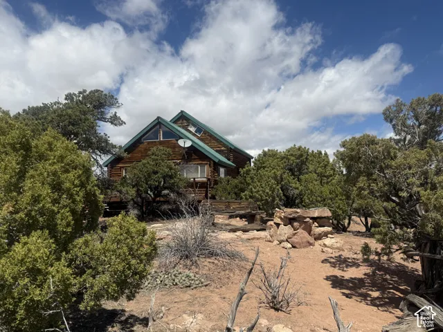 Wood-sided residence featuring a green metal roof and a prominent A-frame window design