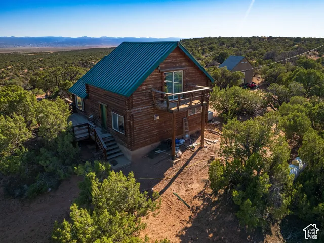 Rustic log cabin featuring a metal roof, an elevated deck, and a secondary building