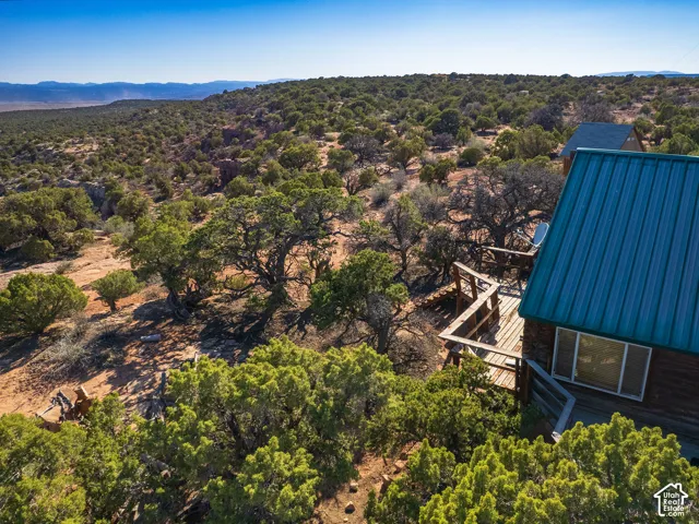Wood-sided structure featuring a metal roof and a wooden deck
