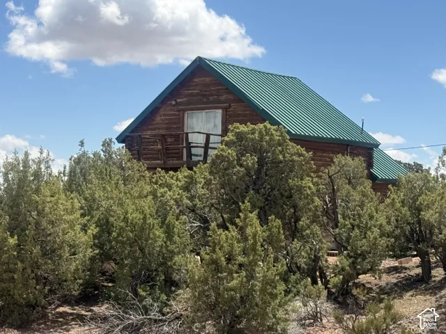 Log cabin style exterior with a distinctive green metal roof