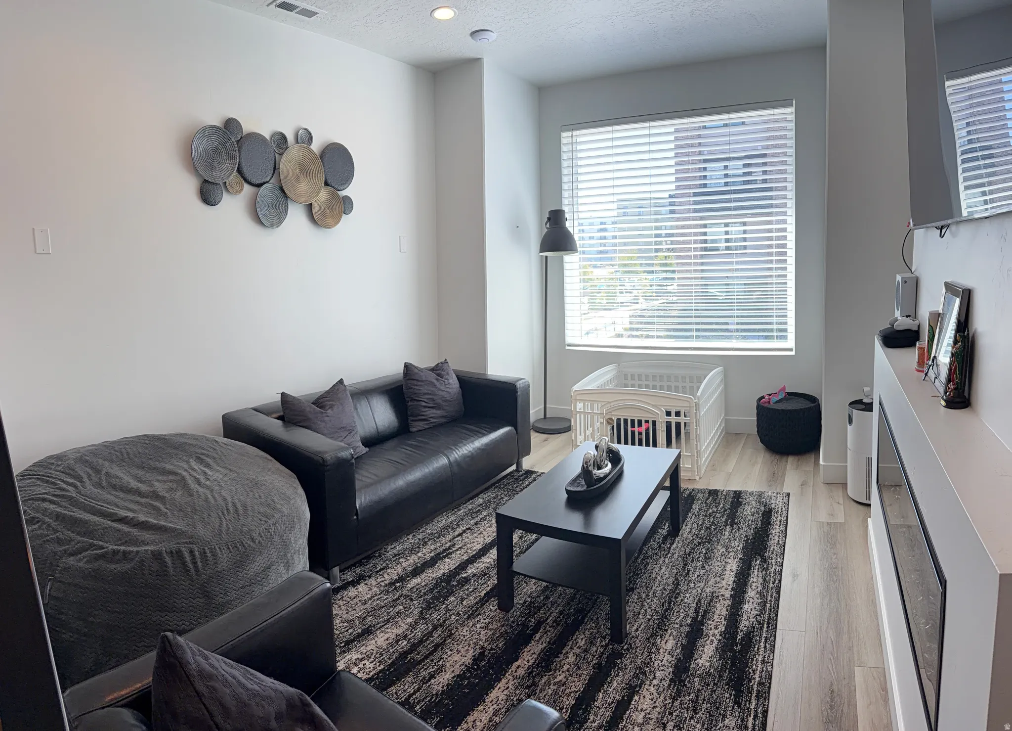 Open-concept living area featuring light wood-finish flooring and recessed lighting