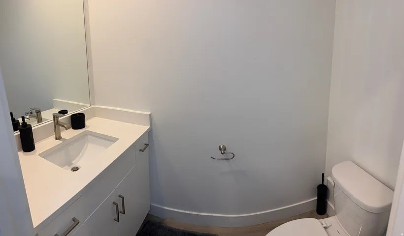 Bathroom featuring a white vanity with an integrated sink, brushed nickel faucet, and a large wall-mounted mirror