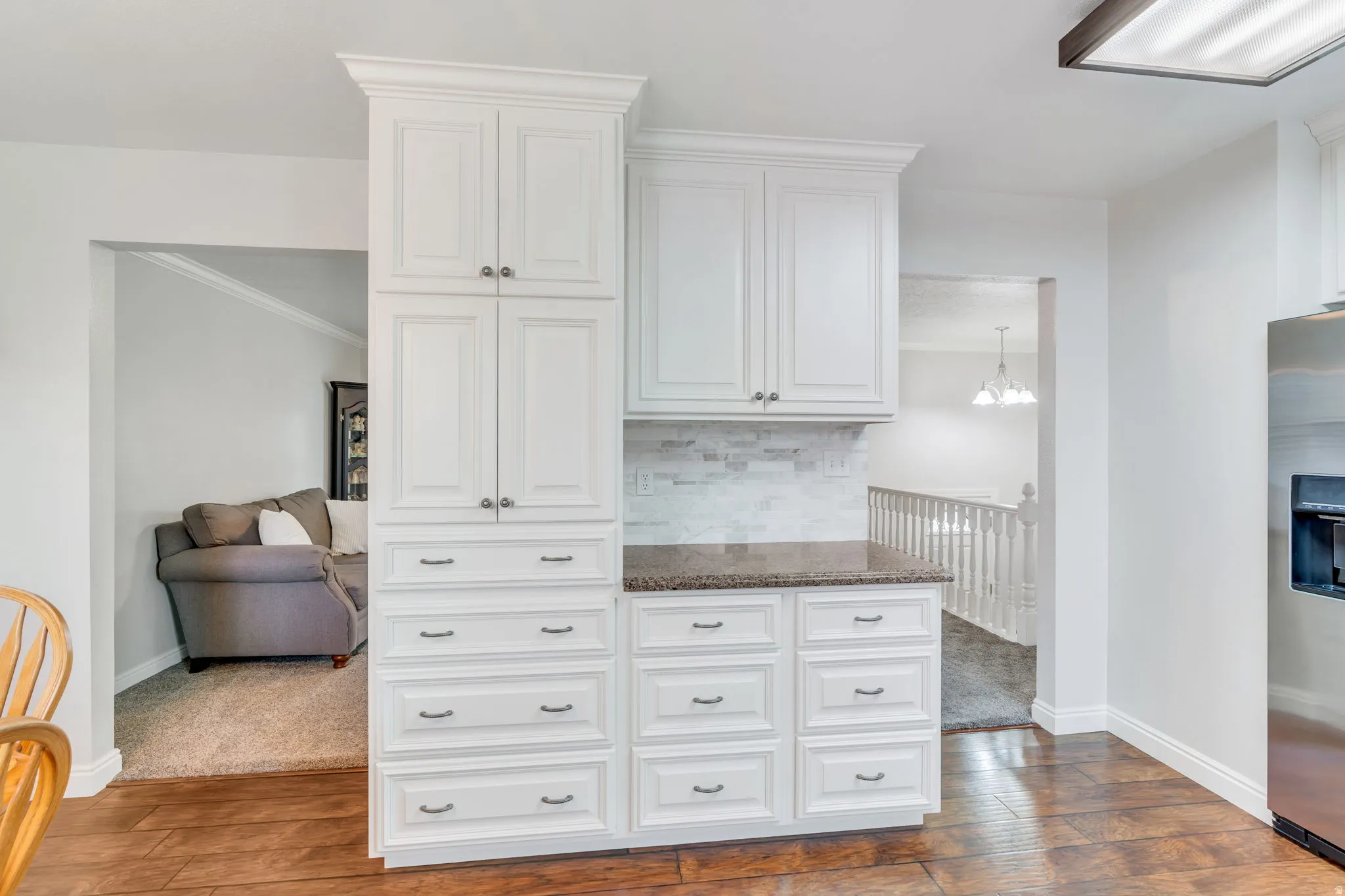 Kitchen cabinetry featuring white shaker-style doors and drawers with brushed nickel hardware