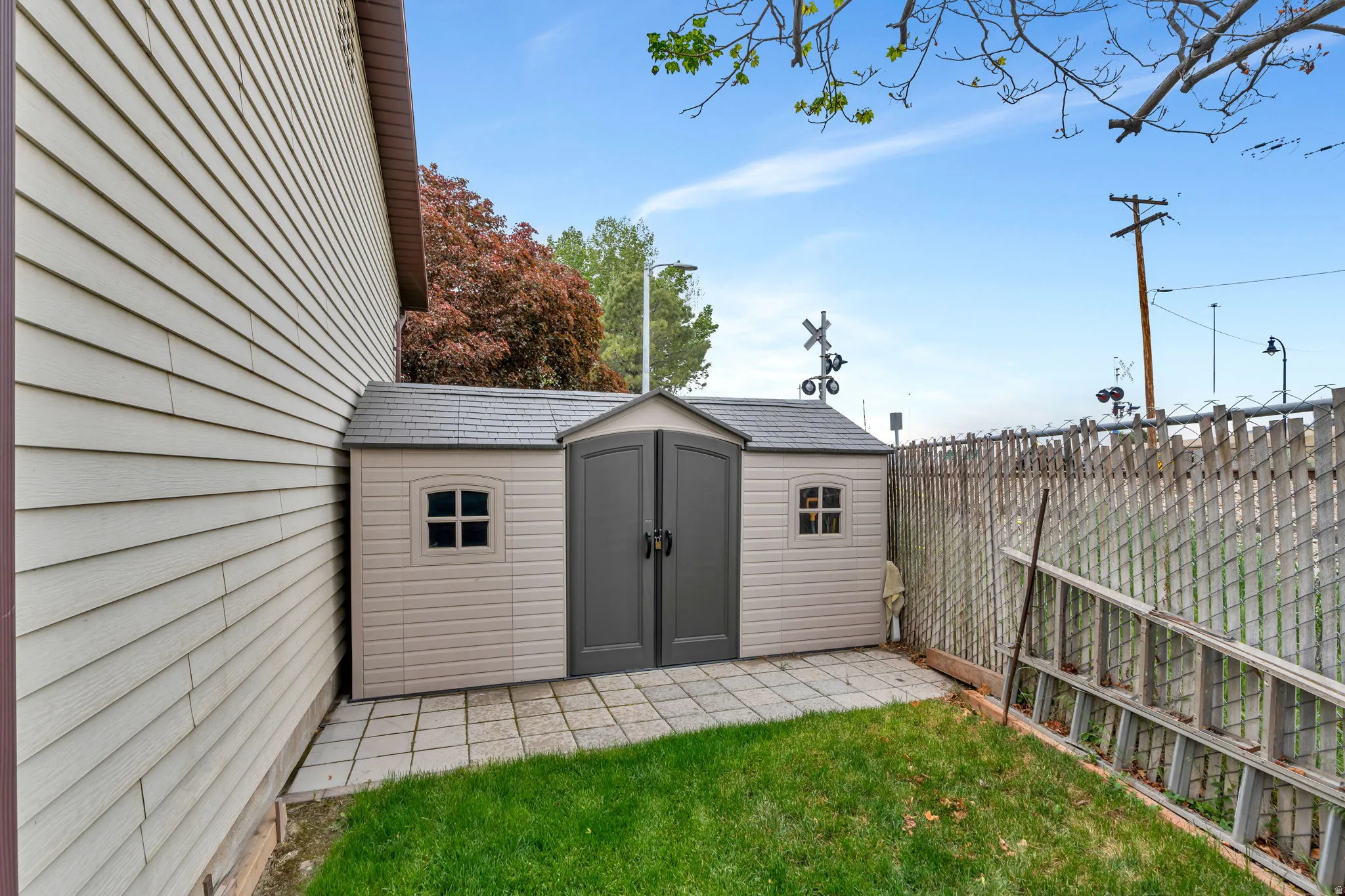 Outdoor storage shed featuring double doors and small windows