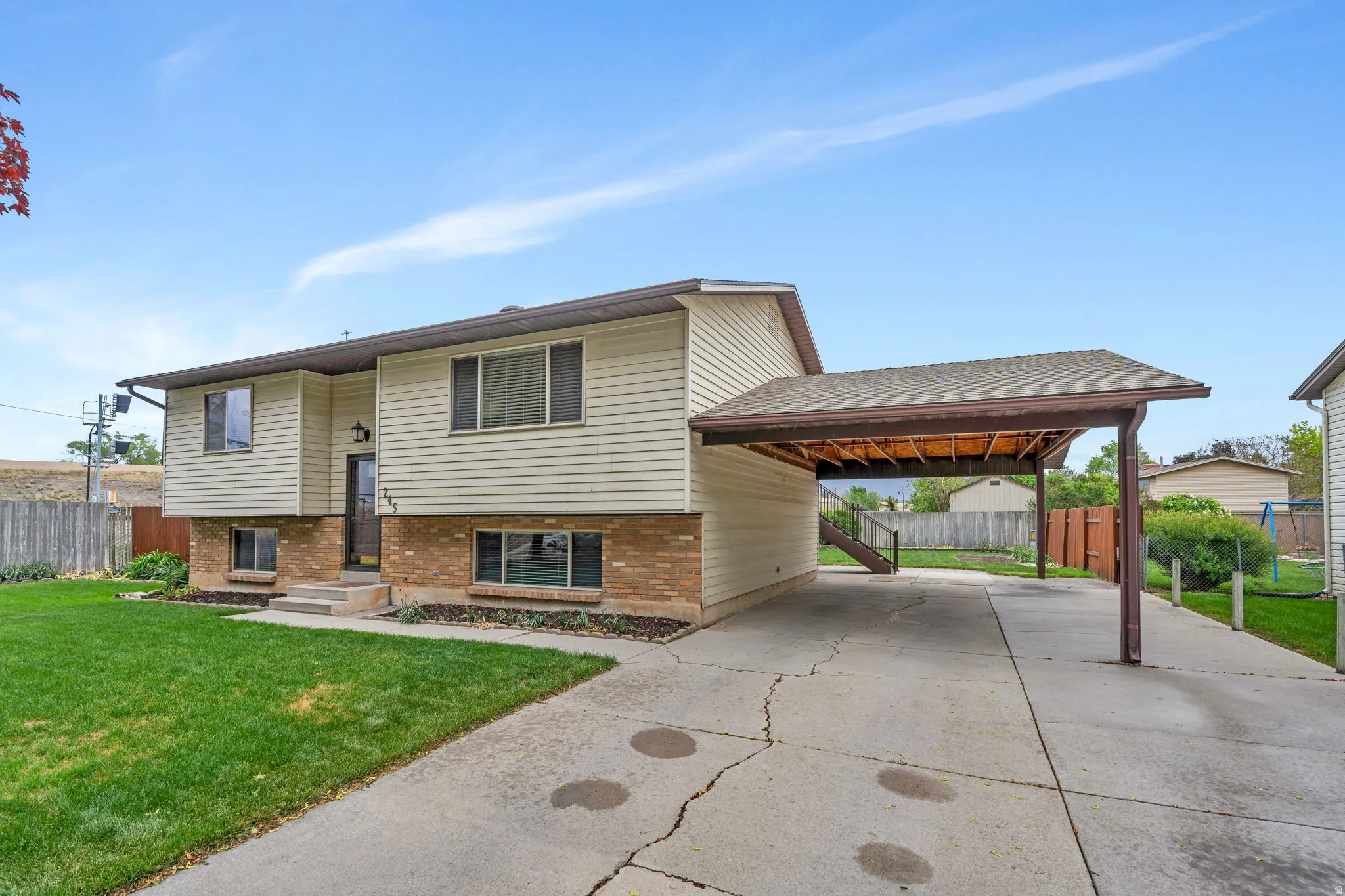 Split-level residence featuring vinyl siding and a brick facade
