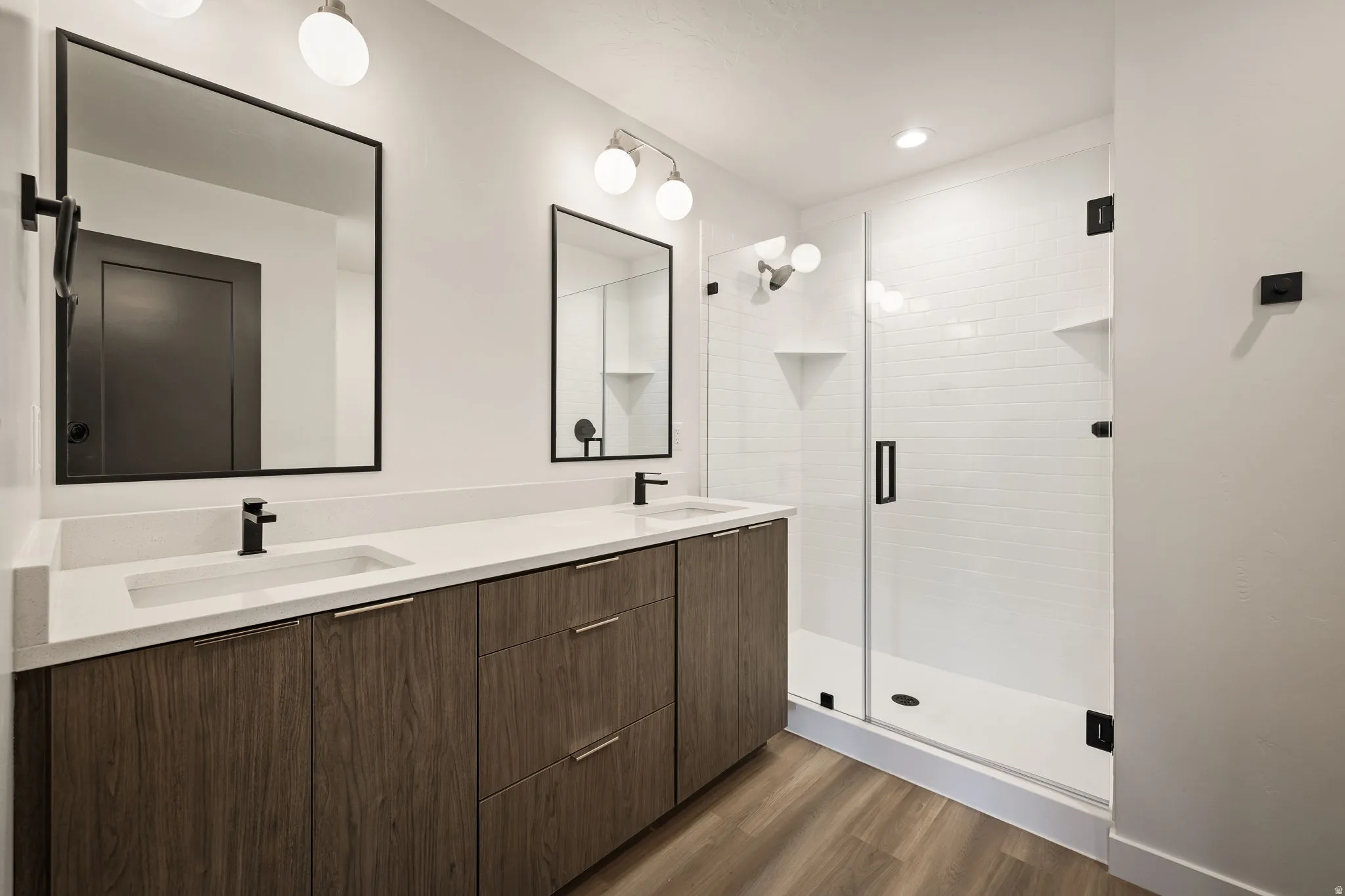 Bathroom featuring a double vanity with wood-finish cabinetry, white countertops, and integrated rectangular sinks