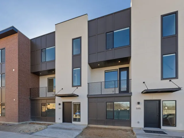 Modern townhome exteriors featuring brick and dark paneling accents