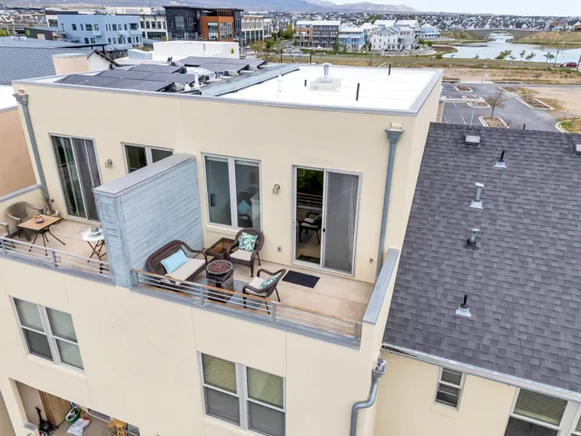 Rooftop patio with a metal railing and sliding glass door access