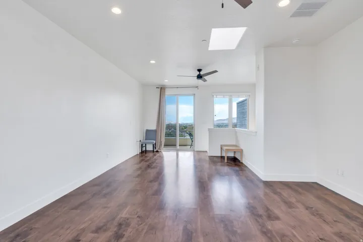Spacious interior featuring wood-finish flooring, recessed lighting, and a ceiling fan